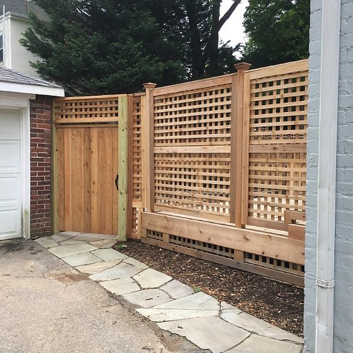 Cedar walk gate beside a full height lattice privacy screen